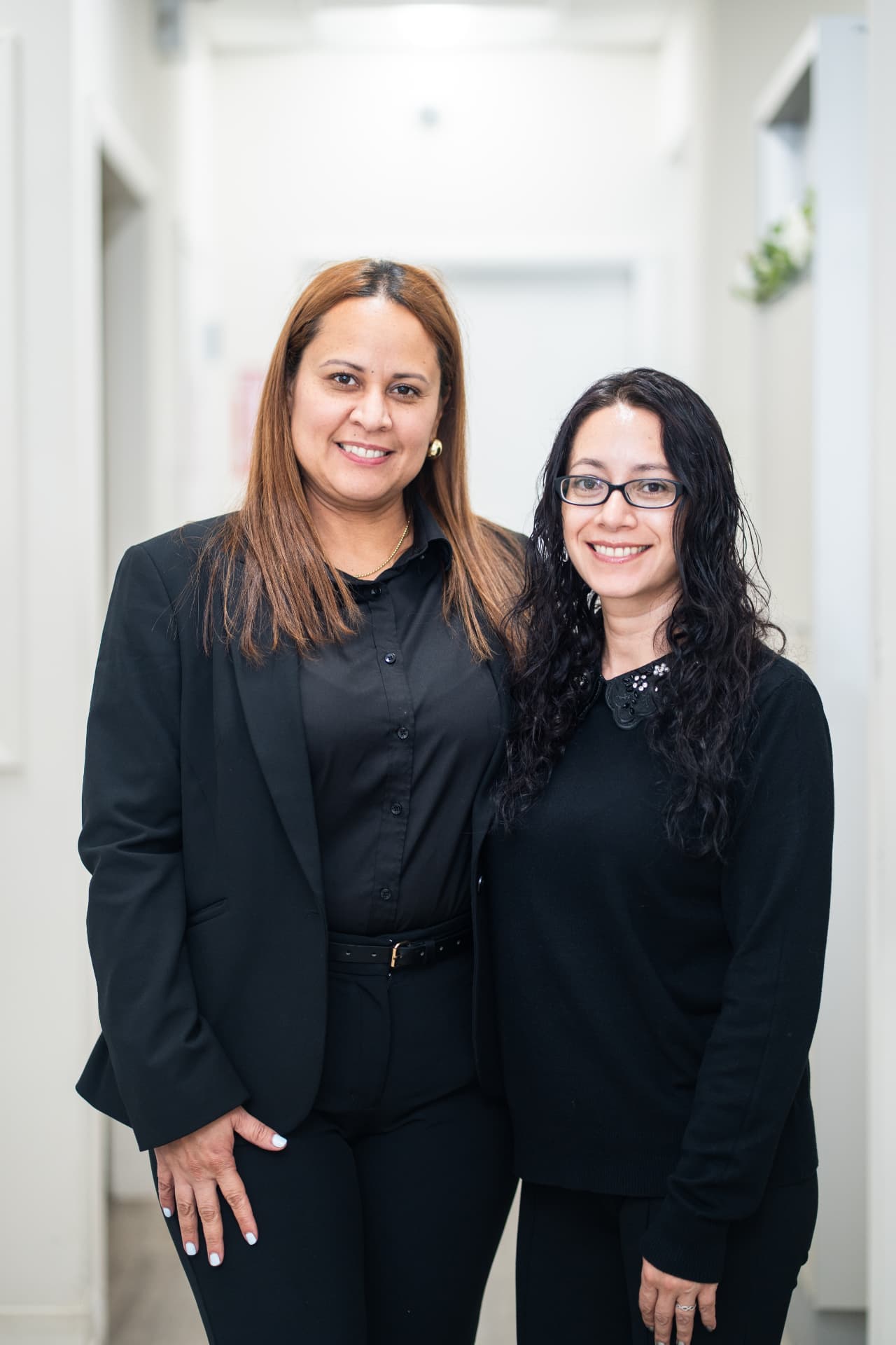 Two Nunez Dental front desk coordinators in the office hallway