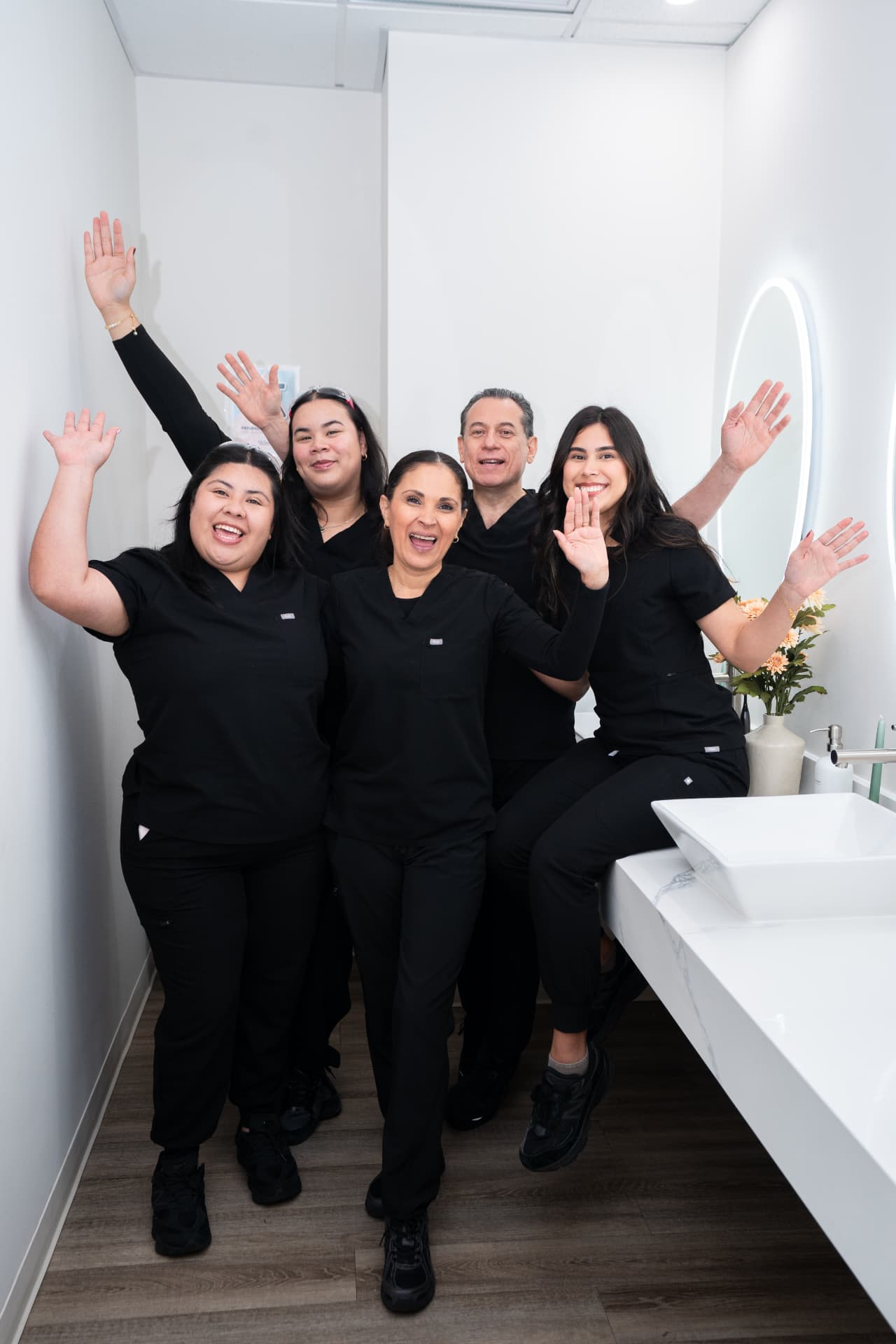 The Nunez Dental team waving inside the Jackson Heights office